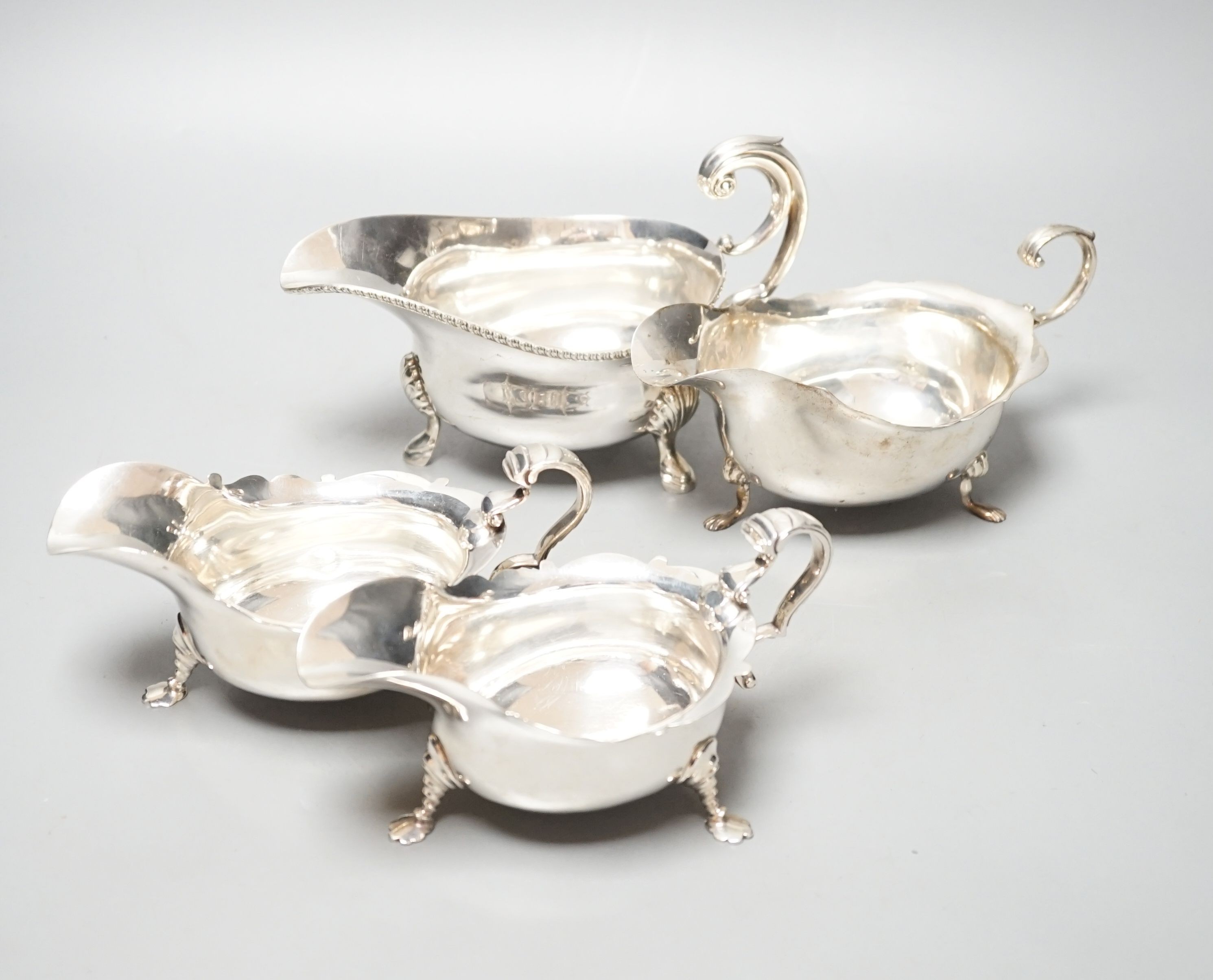 A pair of George V silver sauce boats, London, 1930 and two other larger silver sauceboats, 26oz.